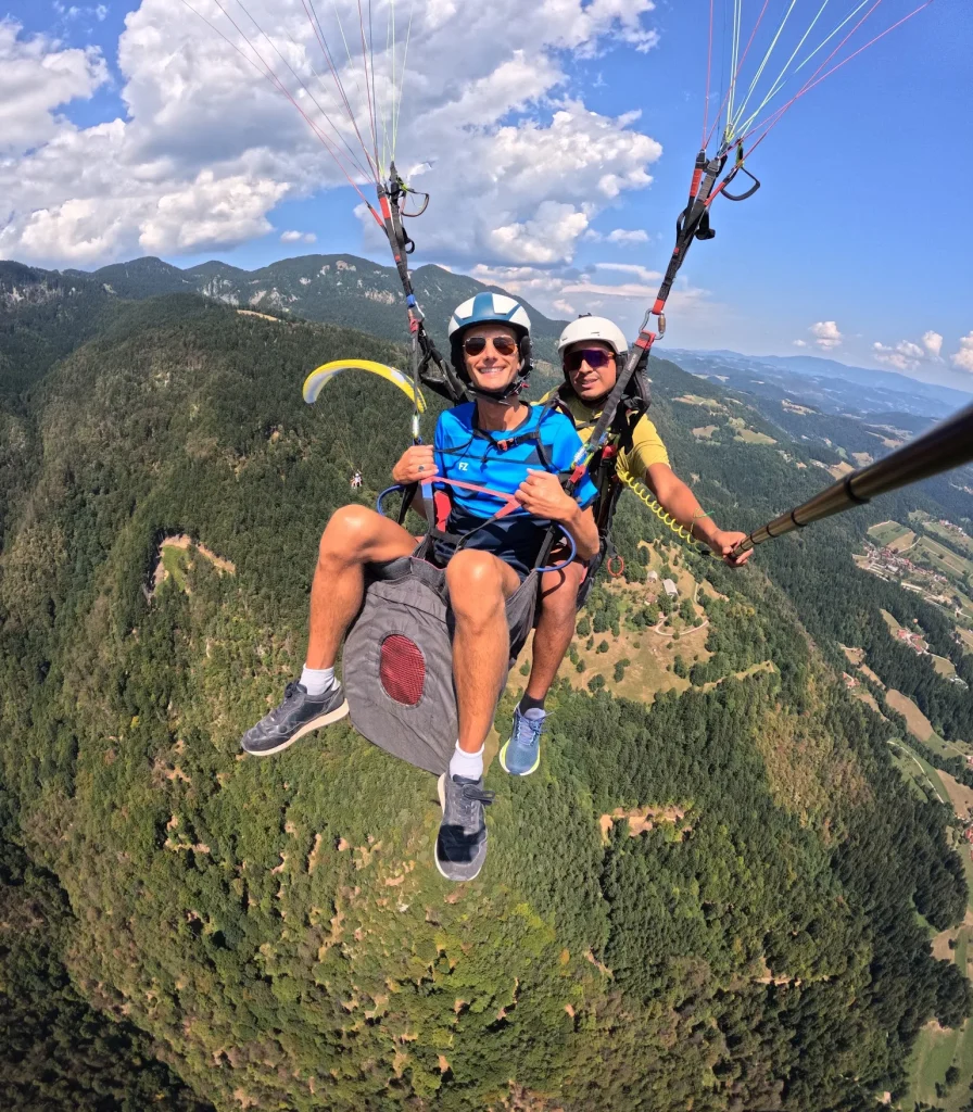 Nasmejan potnik in pilot Impulse med tandemskim poletom z jadralnim padalom